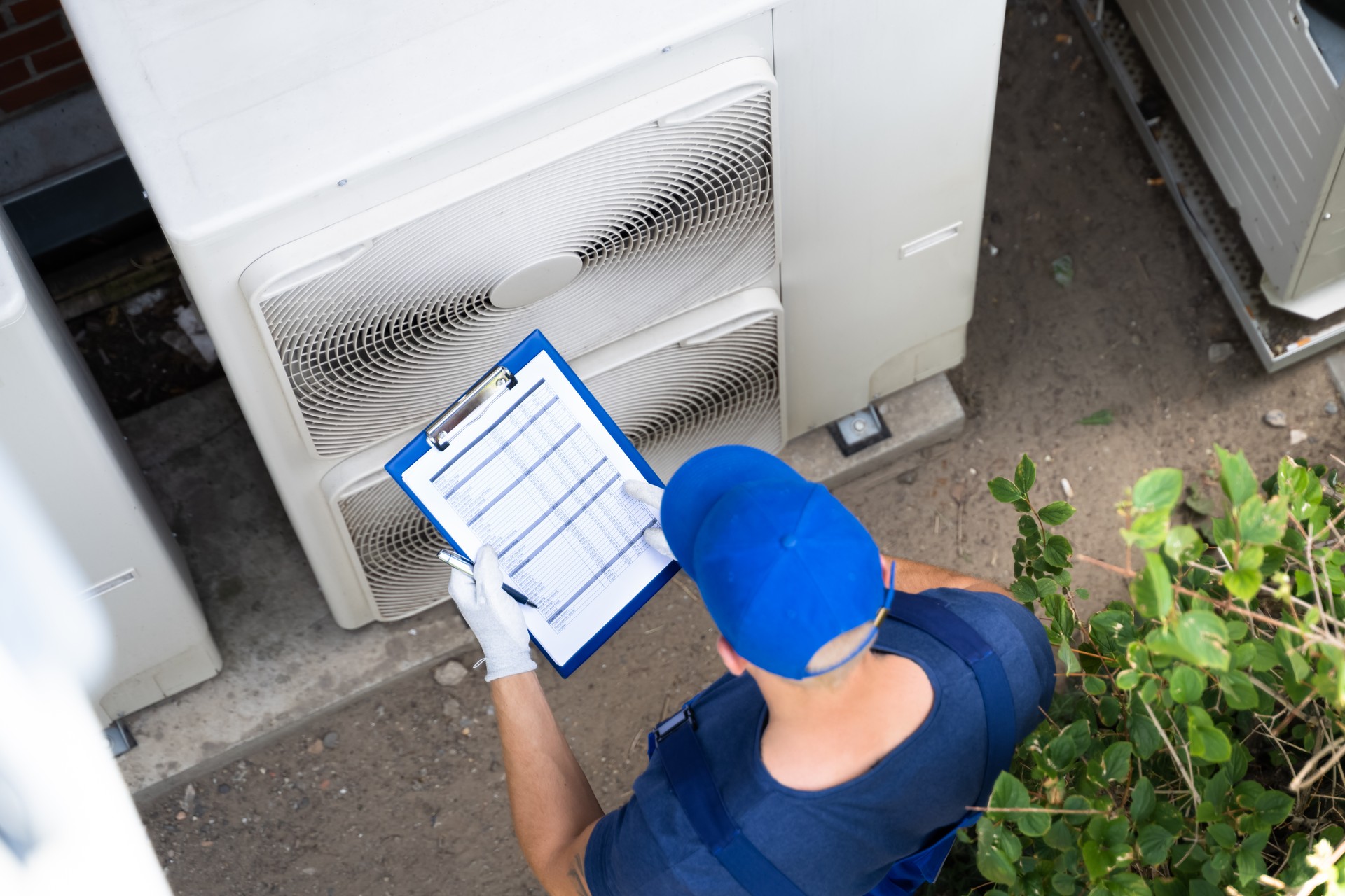 An HVAC Man Checking Air Conditioning Unit